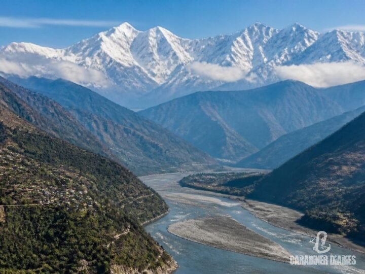 Snow-capped Himalayan peaks above a river valley in Uttarakhand